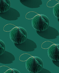 Paper Christmas Ornaments, hanging green New Year decorations as round balls. Minimal aesthetic holidays pattern, green monochrome design, repeated arrangement, top view of craft winter xmas bauble