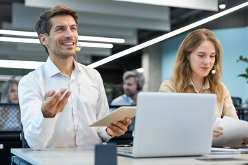 Happy young male customer support executive working in office.