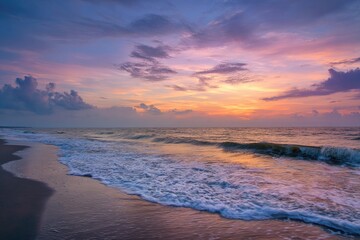 A beach scene with ocean waves under a colorful, cloudy sunset sky