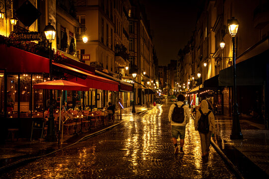 Night View of Restaurants and Caf&eacute;s on Rue Montorgueil with Reflections after Rain &ndash; Paris, France