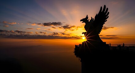 Grand mythical bird statue silhouetted by stunning sunrise, an iconic symbol of power and majestic beauty