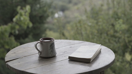 Coffee and Book on a Wooden Table in Nature