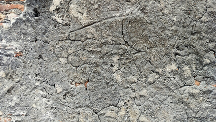 old cracked concrete wall with exposed red brick texture. vintage grunge wall background showing aged plaster peeling off