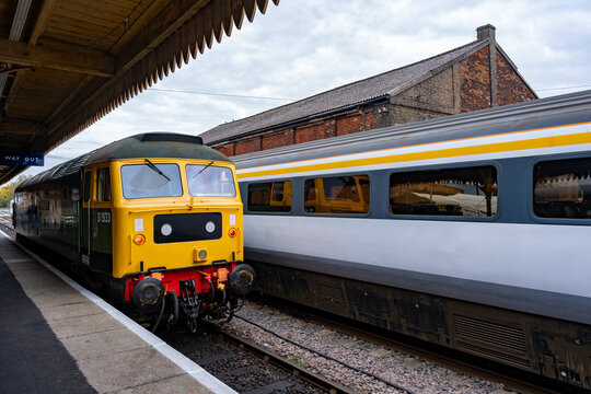 Diesel train departing the platform in Dereham train station on the Mid-Norfolk Railway