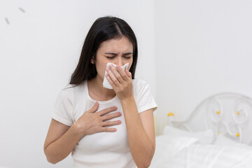 Sick women sneezing into tissue and holding her chest, concept of cold, flu, allergy, or respiratory illness, suitable for healthcare, seasonal illness, and medical awareness content.