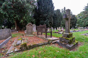 Wooden memorial bench overlooking the ornate gravestones on the military cemetery in Dereham, Norfolk
