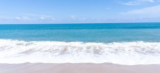 Deep blue sea with whitecap of wave into the coast and blue sky whit thin fluffy clouds in the distance taken at the sea in Phuket South of Thailand used as blue natural background texture