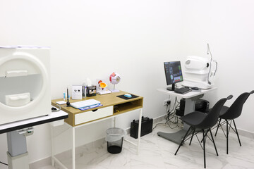 Modern autorefractor with monitor, keyboard, and mouse in a white clinical setting, used for...