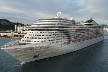 Massive Italian family cruiseship cruise ship Fantasia, Splendida or Divina in Barcelona, Spain during Summer Mediterranean cruising in sleek modern design with port infrasctructure and marine traffic