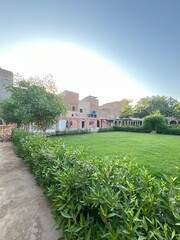 Peaceful Garden Courtyard with Green Lawn and Traditional Architecture Under Clear Sky