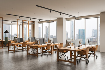 Modern open space office interior with wooden desks, rolling chairs, and large windows showing cityscape background with natural daylight atmosphere. 3D Rendering