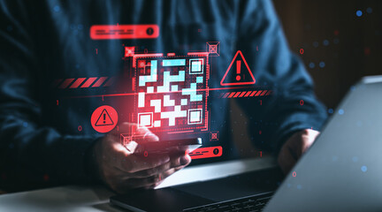 Cybersecurity threat concept showing fake QR code virus alert on digital interface with person using smartphone and laptop in dark workspace environment.