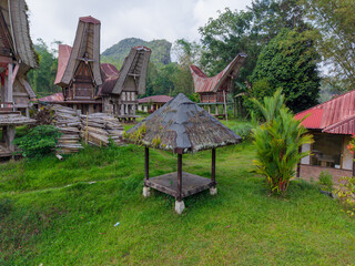 Aerial view of the traditional Tongkonan houses in Ke’te Kesu village, Tana Toraja, Indonesia, surrounded by lush green rice fields.  
