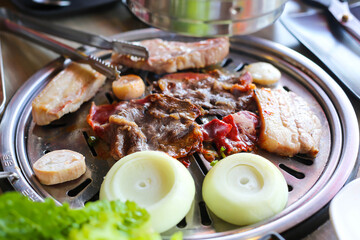 Korea BBQ style restaurant. Asian traditional pickle vegetable ingredients on table with people grilling background.
