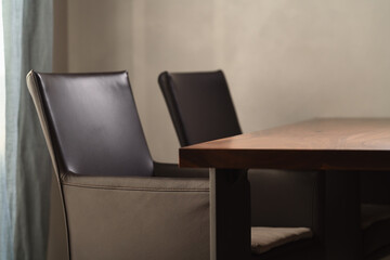 Minimalist kitchen interior with walnut dining table and leather arm chairs