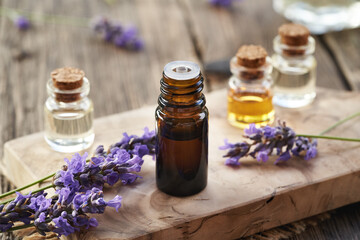 A brown bottle of essential oil with blooming fresh lavender flowers