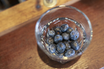 Simple glass of fresh blueberry on rustic wooden table. healthy fruit snack, perfect choice for natural and organic lifestyle. Food viewed from high angle
