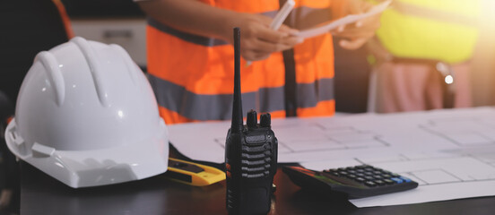 Closeup of team of industrial engineers meeting analyze machinery blueprints consult project on table in manufacturing factory. Working in manufacturing plant or production plant.