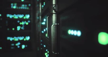 Colorful lights flicker from server racks in a data center, showcasing advanced technology. The environment is dimly lit, emphasizing the vibrant green and blue hues while equipment hums softly. © icetray