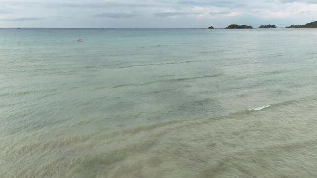 Aerial view of a shallow beach on Bintan Island with calm waves changing tides and clear coastal waters creating a peaceful tropical atmosphere