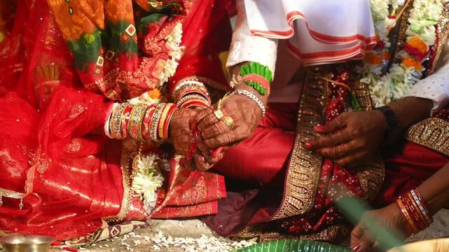 Hands of the bride and groom in wedding Ceremony. Hindu wedding ritual. Odia Wedding. Hindu Wedding Ceremony with Burning Fire and Offering Ritual with People and Golden Details.