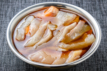 生魚の切り身を漬けダレに漬ける調理シーン。
