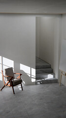 Minimalist 3D interior render of an empty art studio or contemplation room. Wood and fabric chair bathed in strong afternoon sun and shadow. Modern, empty room with easel and stairs. Concept for peace