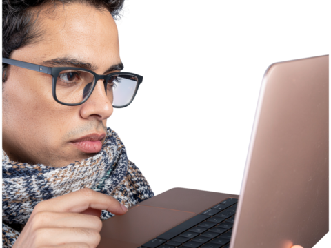 Focused man working on laptop late at night wearing glasses transparent background