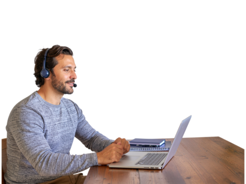 Smiling man works at desk with laptop and headphones on transparent background