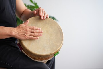 Hands playing a traditional drum, showcasing rhythm and cultural expression