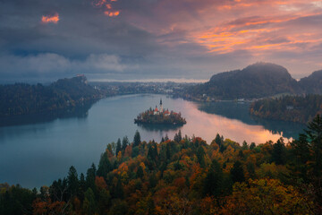 Sunrise over Lake Bled in Slovenia, with warm morning light illuminating the island church and the...