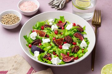 Salad with figs, feta cheese, pomegranate, and pecans. Healthy eating. Vegetarian food.