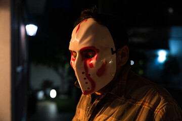Portrait of a man wearing a hockey mask on Halloween. Murderer, murder, cruel and homicidal.