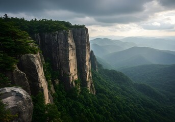 Dramatic Cliffs Overlooking Misty Mountain Range at Dusk