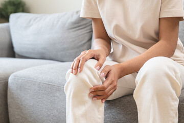 person feeling pain in her knee from injury