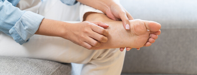 Close-up bare feet of person feeling itchy and irritated try to scratching by toe. © Pormezz