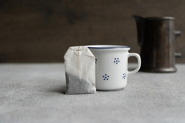 Rustic cup and tea bag and tea pot