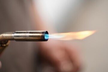 Close-up of a gas torch producing a vibrant blue flame for welding