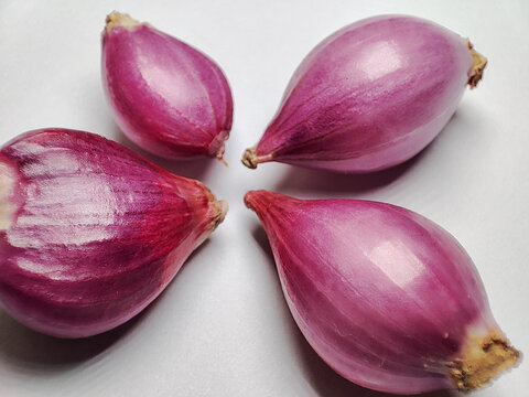 macro photo of several shallots on a white background