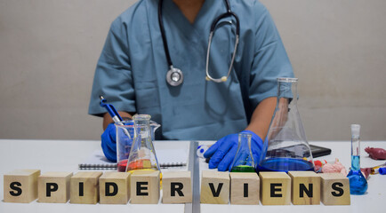 A healthcare professional taking notes with scrabble letters spider viens. scientific research...
