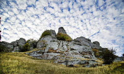 Cliffs in the Demerdzhi mountain range on a clear sunny day against a backdrop of beautiful cirrus clouds. Landscape, sights of Russia, sea, mountains.
