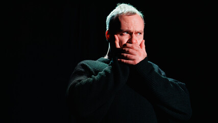 Emotional performer covering mouth on theater scene 