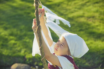 Charming girl washing clothes in the garden. Retro portrait