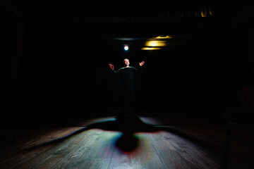 Actor performing on theater scene with lighting 