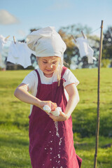 Charming girl washing clothes in the garden. Retro portrait