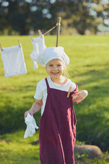 Charming girl washing clothes in the garden. Retro portrait