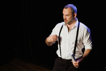 Actor playing role of offended man and holding scenario on stage 