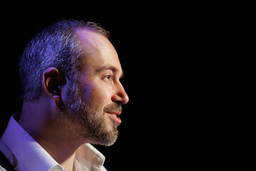 Profile of smiling actor talking on black background