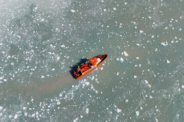 Fototapeta premium An awe inspiring aerial perspective captures a modern cruise ship gracefully navigating the icy waters in front of the colossal Eqi Glacier in Greenland