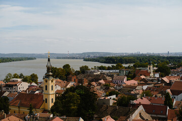 Obraz premium Wide panorama of Zemun rooftops and the Danube River with distant view of Belgrade skyline